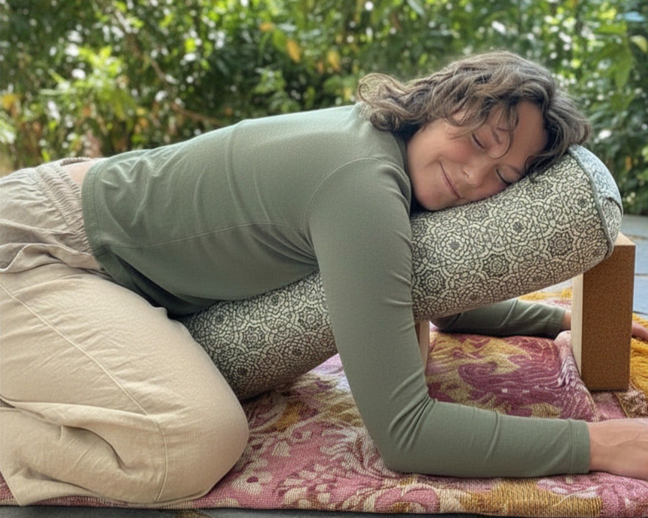 Comfortable restorative rest position with bolster support at Beautiful Yoga Voice and Rest circle