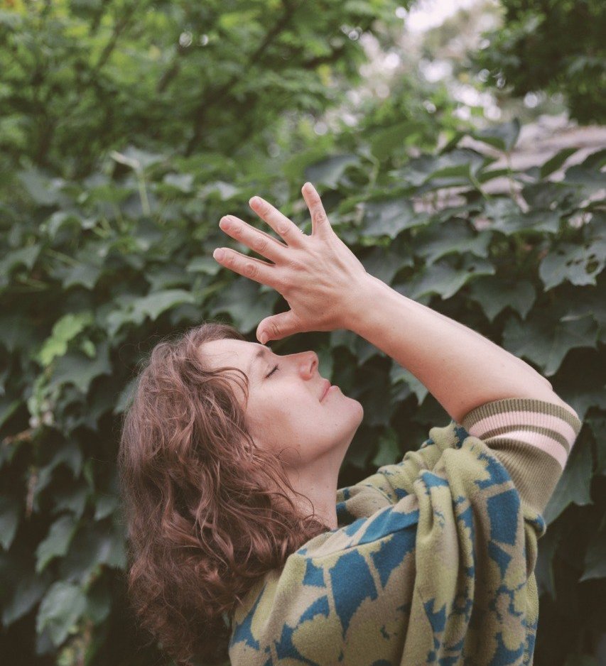 Joyful reaching toward sky gesture in natural setting representing openness and connection
